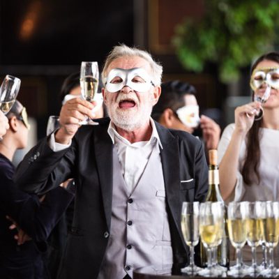 Group of office worker in fancy mask having celebration party. people cheers toasting wine glasses and talking together with senior boss. business corporate company meeting in New Year party concept
